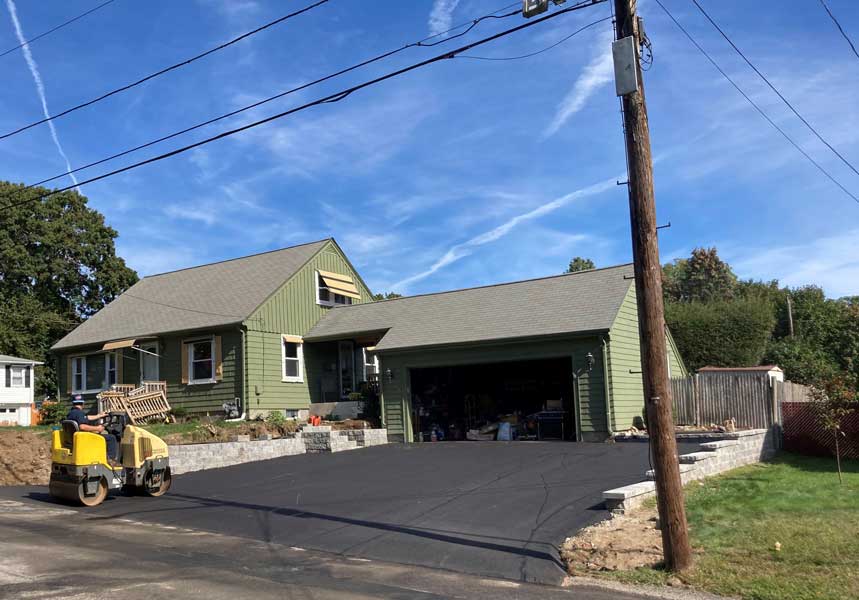 Asphalt driveway installation at a residential home, showing paving contractor services in Cranston