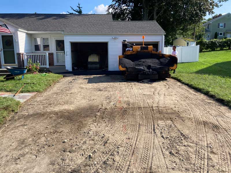 Asphalt driveway grading with paving equipment for residential paving services in Cranston, RI