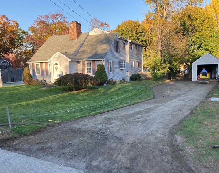 Damaged residential driveway surface before asphalt paving in Cranston, RI